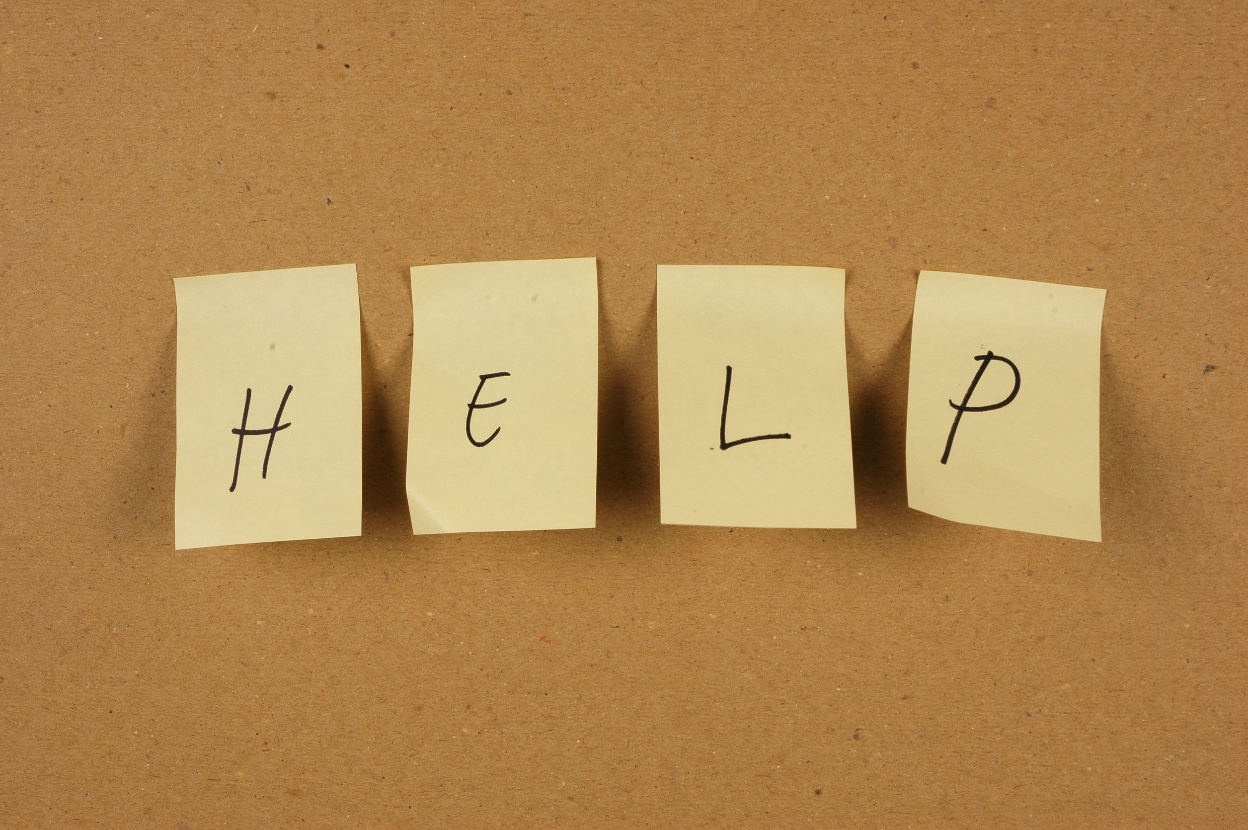 Post-it notes written "help" on bulletin board