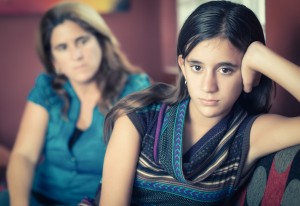 young girl ignoring parent behind her