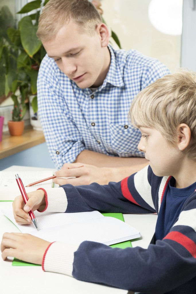 Teacher helping troubled student with school work in classroom.