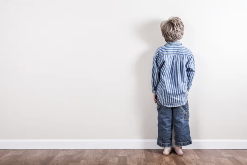 little boy at time out corner.