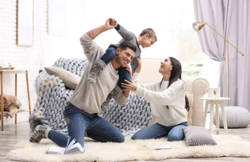 Mother and father playing with son in bedroom