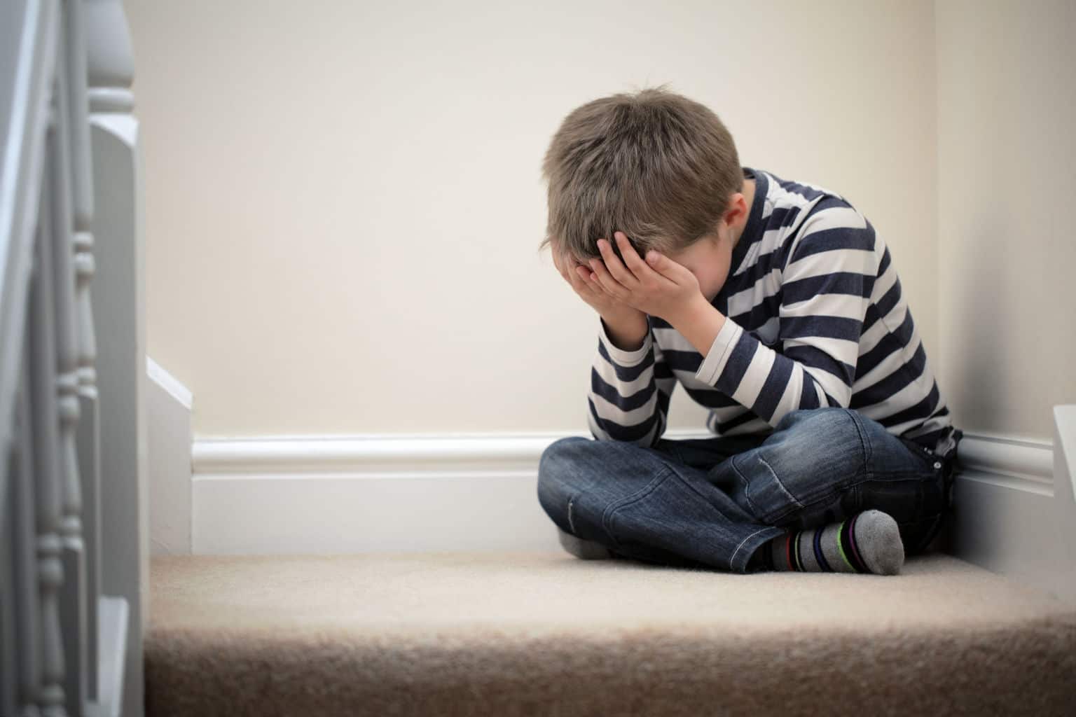 Child with PTSD Crying sitting in corner steps