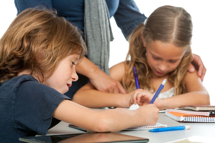 tutor helping two kids with homework