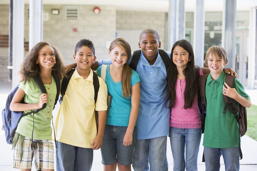 Group of tweens smiling in school.