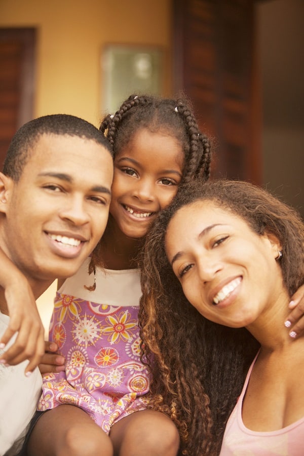 Mother and Father and daughter smiling.