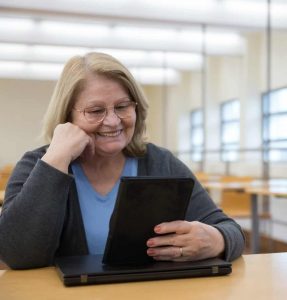 Older woman watching webinar on her tablet