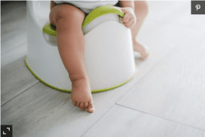 Close up of toddler sitting down potty training