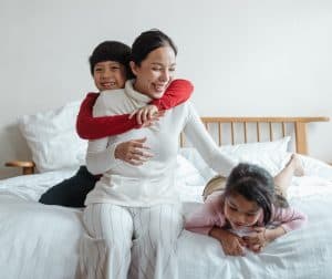 Mother in bed with two children who have ADHD. 