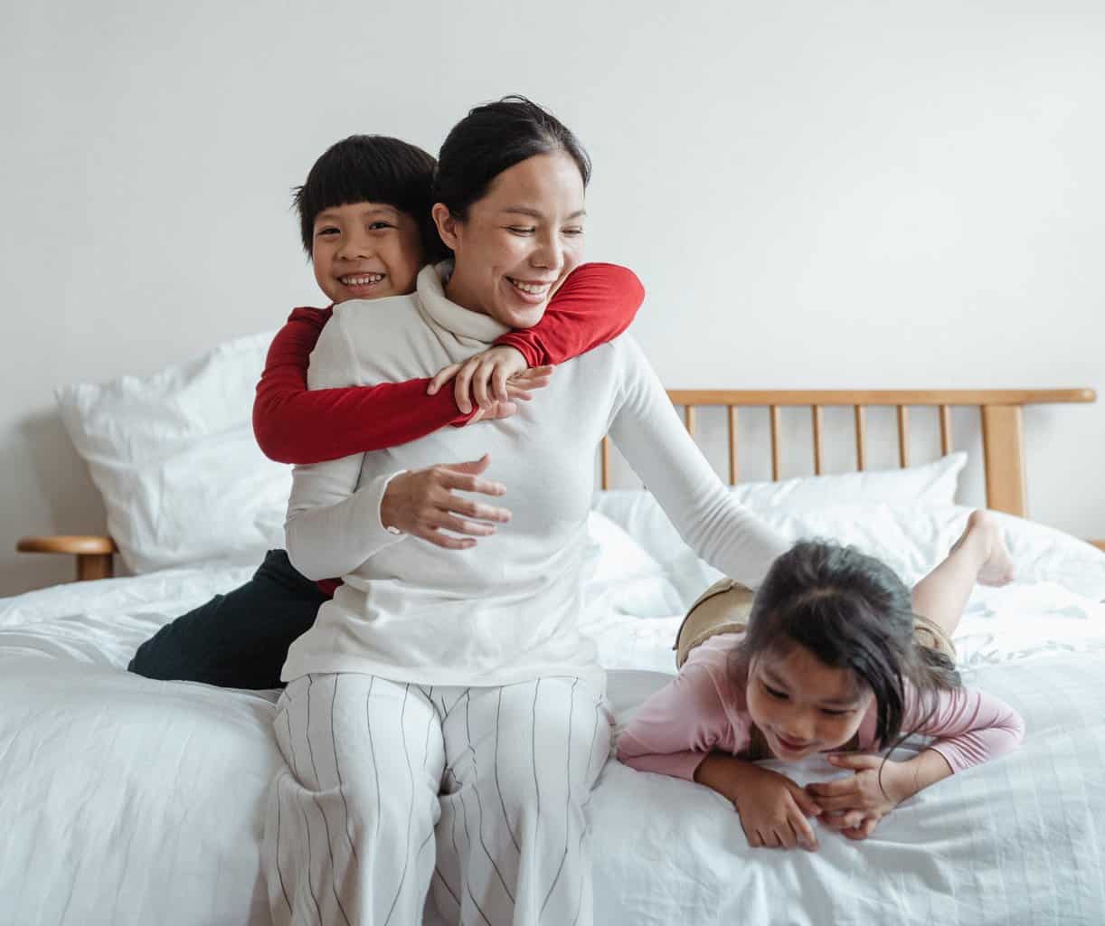 Mother with children on bed who have adhd.