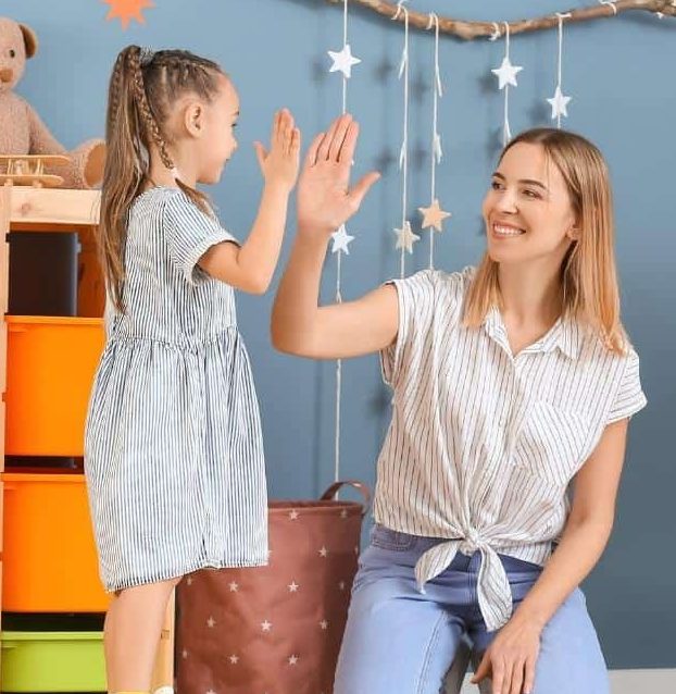 aba therapist smiling and giving high five to child in private session.