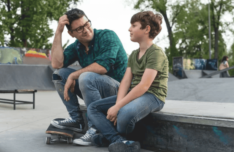 Father talking to son at park.