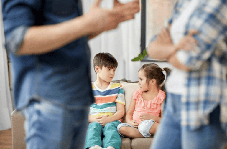 Kids sitting on couch while parents argue