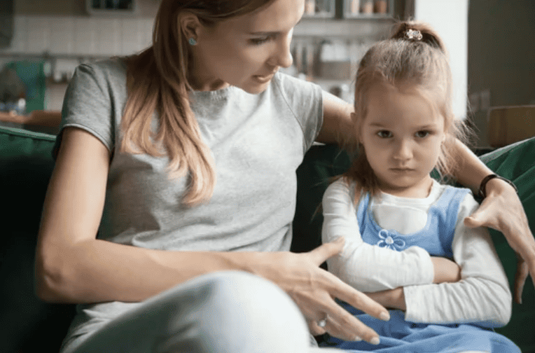 Mother talking to young girl about her actions. Young girl upset.