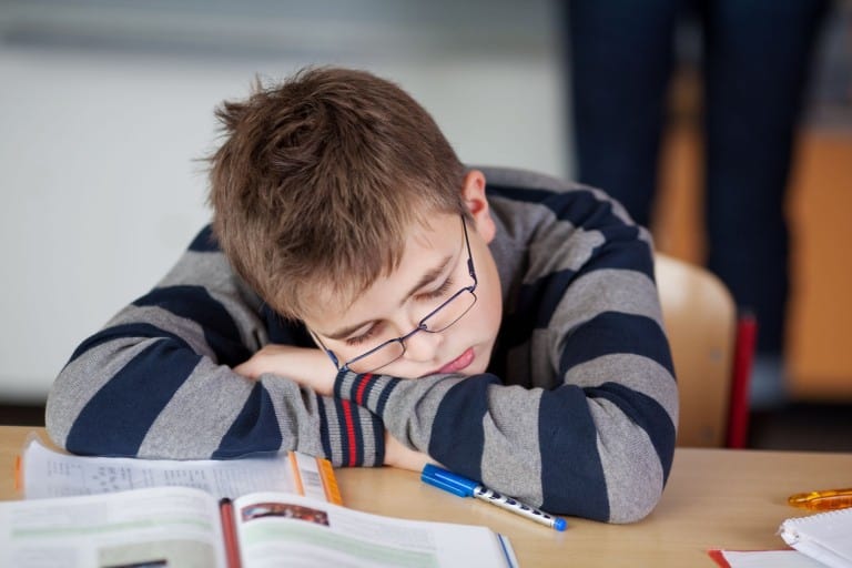 Boy sleeping in classroom.