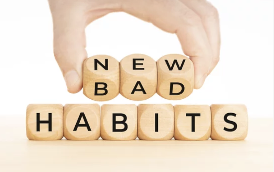 small word blocks spelling out bad habits and hand flipping it to say new habits.