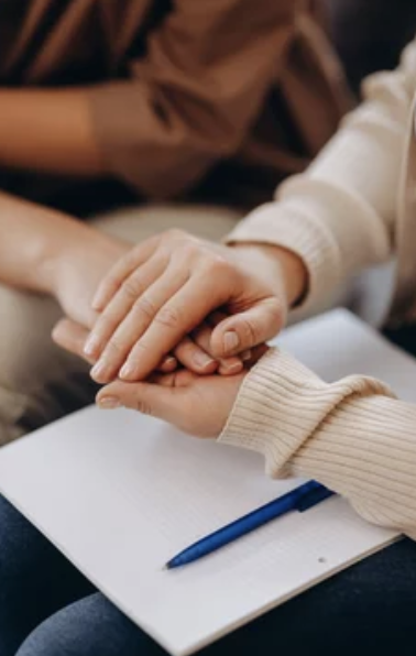 close up of psychologist holding patients hands in therapy session