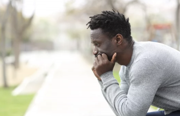 depressed/anxious man sitting down looking stresed