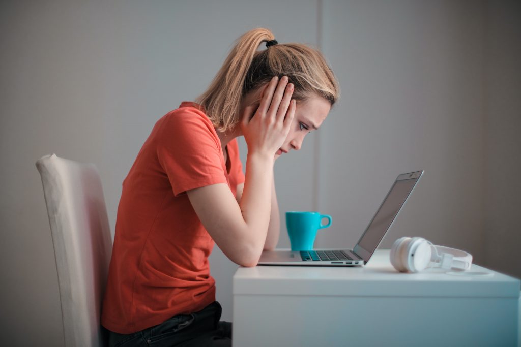 woman trying to concentrate looking at laptop