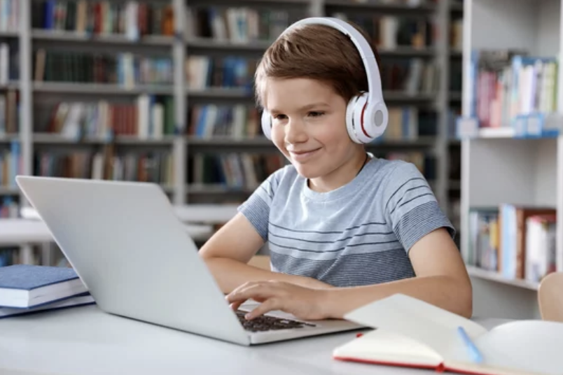 young Boy on laptop being tutored online.